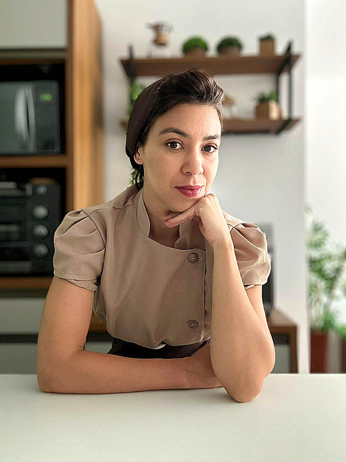 Lindeise apoiada na bancada da cozinha