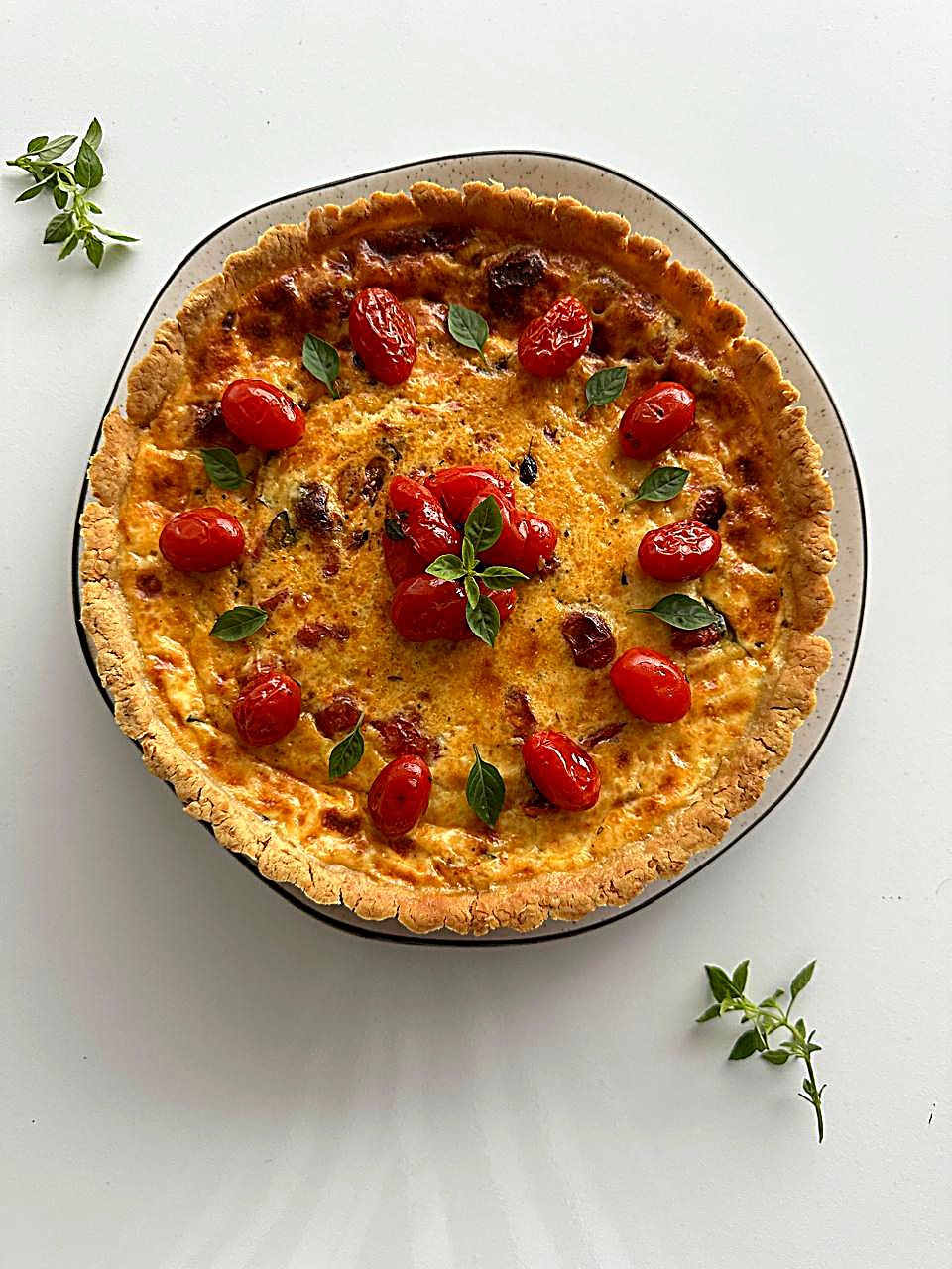 Quiche vista de cima com tomate cereja e manjericão
